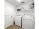 Bright laundry room with tile floor, washer and dryer, and a door to a secondary area at 29 Guava Pass, Ocklawaha, FL 32179