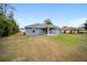 Exterior view of the home showcasing a spacious backyard and covered patio at 3705 Se 137Th Ln, Summerfield, FL 34491