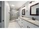 Bright bathroom with a double sink vanity, granite countertops, and tiled walk-in shower at 3705 Se 137Th Ln, Summerfield, FL 34491