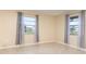 Bright bedroom featuring two windows with decorative curtains and neutral tile flooring at 434 Bar Ct, Kissimmee, FL 34759