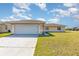 Single-story home displaying attached two-car garage and neutral color palette in a well maintained lawn at 434 Bar Ct, Kissimmee, FL 34759