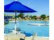 Community pool featuring a large swimming area, lounge chairs, and shade umbrellas at 434 Bar Ct, Kissimmee, FL 34759