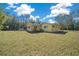 Spacious backyard with ample green space and partial view of house at 4445 Sw Azalea Ct, Dunnellon, FL 34431