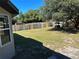 Large fenced backyard features a grassy lawn, mature trees, and a charming gazebo, perfect for outdoor living at 4691 Se 138Th Pl, Summerfield, FL 34491