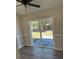 Cozy room with a ceiling fan and sliding glass doors leading to a spacious backyard with a brick patio at 4691 Se 138Th Pl, Summerfield, FL 34491