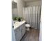 Bathroom featuring a shower with gray-striped curtain, a white toilet, and vanity with gray marbled top at 4691 Se 138Th Pl, Summerfield, FL 34491