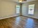 Bedroom with wood-look flooring and natural light from two windows at 4691 Se 138Th Pl, Summerfield, FL 34491