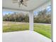 Covered back porch with ceiling fan overlooking the backyard at 47 Sequoia Loop, Ocklawaha, FL 32179