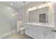 Bright bathroom featuring a double sink vanity, marble-tiled shower, and wood-look tile floors at 47 Sequoia Loop, Ocklawaha, FL 32179