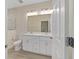 Modern bathroom with double vanity, marble wall in shower, tiled floors, and ample lighting at 47 Sequoia Loop, Ocklawaha, FL 32179