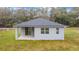 Rear exterior view of home with covered back porch and sliding glass door at 47 Sequoia Loop, Ocklawaha, FL 32179