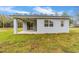 Rear exterior view of home with covered back porch and sliding glass door at 47 Sequoia Loop, Ocklawaha, FL 32179