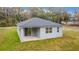 Rear exterior view of home with covered back porch and sliding glass door at 47 Sequoia Loop, Ocklawaha, FL 32179