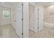 Hallway with neutral walls, tile floors, and multiple doors leading to other rooms at 47 Sequoia Loop, Ocklawaha, FL 32179