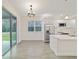 Bright kitchen with white cabinets, stainless steel appliances, island, and wood-look tile floors at 47 Sequoia Loop, Ocklawaha, FL 32179