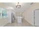 A spacious, well-lit kitchen featuring a white island, tile floors, stainless fridge, and modern lighting at 47 Sequoia Loop, Ocklawaha, FL 32179