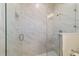 Close-up of the marble tiled shower with a clear glass door at 47 Sequoia Loop, Ocklawaha, FL 32179