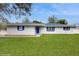 Charming white brick home featuring a well-manicured lawn and bright blue window shutters at 506 Clear Rd, Ocala, FL 34472