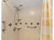 Shower features neutral tile, handrails, and multiple shower heads in a cozy bathroom at 527 Midway Dr # A, Ocala, FL 34472