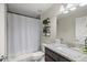 Well-lit bathroom featuring a granite countertop, decorative shelves, and a shower with a curtain at 5488 Nw 61St Ave, Ocala, FL 34482