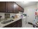 Functional laundry room with ample counter space, dark wood cabinets, and modern appliances at 5488 Nw 61St Ave, Ocala, FL 34482