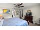 This main bedroom has a ceiling fan, carpet floors, and a dresser with a TV at 5488 Nw 61St Ave, Ocala, FL 34482