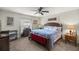 Cozy main bedroom featuring a wooden bed frame, carpet floors, and a ceiling fan at 5488 Nw 61St Ave, Ocala, FL 34482