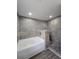 Close-up of modern bathroom featuring a luxurious tub and shower with stone-like tile and pebble floor at 5500 Sw 151St Street Rd, Ocala, FL 34473