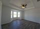 Bright bedroom with a tray ceiling, ceiling fan, and large bay window at 5500 Sw 151St Street Rd, Ocala, FL 34473