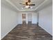 Bedroom features tray ceiling, fan, closet, en suite bathroom, and wood-look flooring throughout at 5500 Sw 151St Street Rd, Ocala, FL 34473