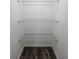 Walk-in closet with three rows of white wire shelving over dark laminate flooring at 5500 Sw 151St Street Rd, Ocala, FL 34473