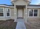 Inviting covered front entry featuring a classic door and decorative columns, exuding warmth and charm at 5500 Sw 151St Street Rd, Ocala, FL 34473