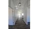 Hallway with wood flooring and pendant lighting leads to the kitchen area at 5500 Sw 151St Street Rd, Ocala, FL 34473