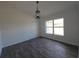 Open living room with wood-look floors, a pendant light, and a large window for natural light at 5500 Sw 151St Street Rd, Ocala, FL 34473