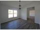 Open living room with wood-look floors, a pendant light, and a large window for natural light at 5500 Sw 151St Street Rd, Ocala, FL 34473