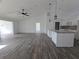 Open-concept living room with vaulted ceiling, modern light fixtures, and wood-look flooring at 5500 Sw 151St Street Rd, Ocala, FL 34473