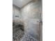 Shower with a stone tile surround and pebble flooring at 5500 Sw 151St Street Rd, Ocala, FL 34473