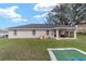 View of the backyard featuring a covered porch, play area, and well-maintained lawn, perfect for outdoor enjoyment at 5910 Sw 89Th St, Ocala, FL 34476