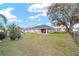 Spacious fenced backyard with a covered patio, lush grass, and mature tree at 5910 Sw 89Th St, Ocala, FL 34476