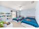 Bright bedroom featuring two twin beds, ceiling fan, built-in shelving and neutral colored walls at 5910 Sw 89Th St, Ocala, FL 34476