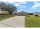 Charming single-story home showcasing a large front lawn, a driveway, and an attached two-car garage at 5910 Sw 89Th St, Ocala, FL 34476