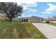 Well-manicured front yard, a driveway leading to an attached two-car garage, and neutral paint tones at 5910 Sw 89Th St, Ocala, FL 34476