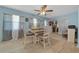 Inviting dining area with light hardwood floors, a ceiling fan, and large windows with sheer curtains at 6196 Sw 84Th Place Rd, Ocala, FL 34476