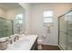 Modern bathroom showcasing a vanity with a quartz countertop, a walk-in shower, and natural light at 6367 Sw 70Th Cir, Ocala, FL 34474