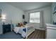 A cozy bedroom featuring blue accents, a comfortable bed, and natural light from the window at 6367 Sw 70Th Cir, Ocala, FL 34474