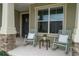 Welcoming front porch view featuring rocking chairs, stone pillars and a decorative wreath on the door at 6367 Sw 70Th Cir, Ocala, FL 34474