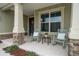 Charming front porch showcasing rocking chairs and stylish stone columns, perfect for relaxing outdoors at 6367 Sw 70Th Cir, Ocala, FL 34474