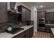 A kitchen features stainless appliances, dark backsplash, dark wood cabinetry, and quartz countertops at 6367 Sw 70Th Cir, Ocala, FL 34474