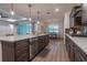 An open-concept kitchen showcases a large center island with quartz countertop and a dining area beyond at 6367 Sw 70Th Cir, Ocala, FL 34474