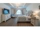 A staged main bedroom is accented by a chandelier, side tables, and a patterned bedspread at 6367 Sw 70Th Cir, Ocala, FL 34474